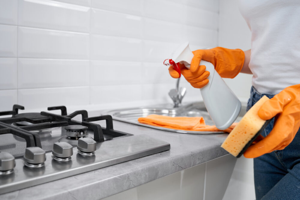 woman holding rag detergent cleaning cooker e1753106980695 Feesauberkeit Inh. Yadviha Saviankova